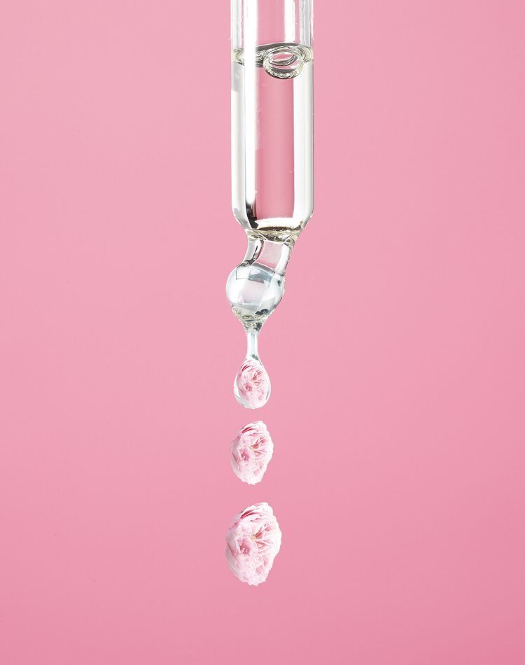 Şeffaf damlalık, pembe gül yapraklı berrak serum damlaları