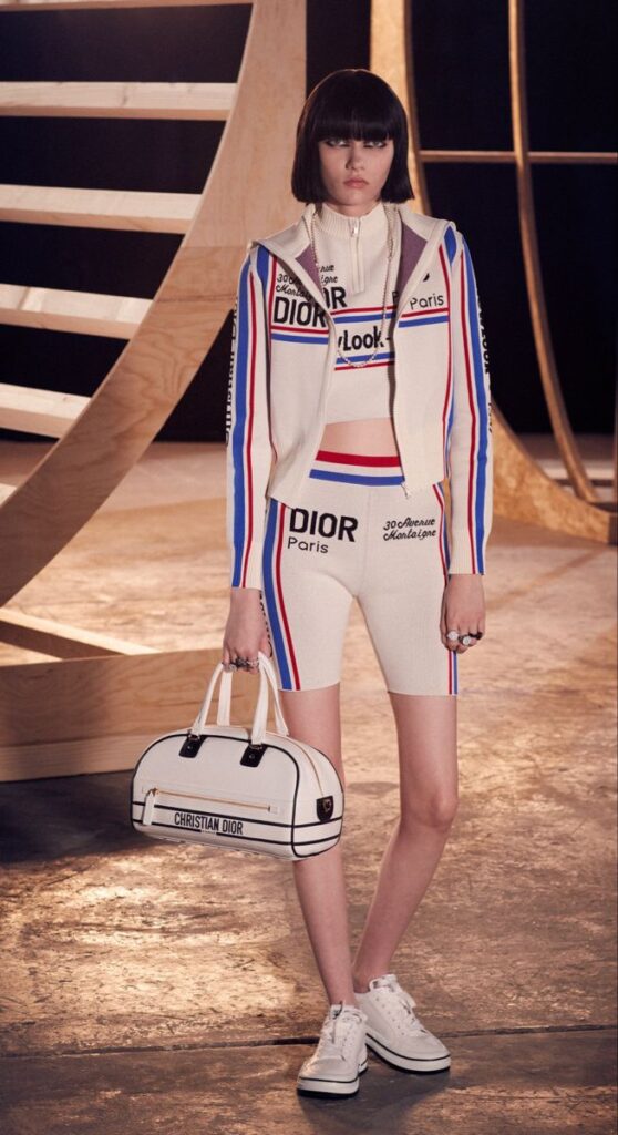 Dior beyaz çizgili spor kıyafet takımı giymiş model ve çantası