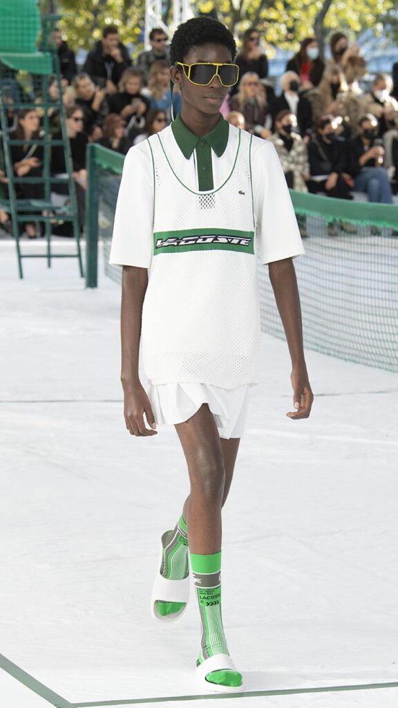 Lacoste moda defilesinde yeşil detaylı beyaz spor kıyafetli model
