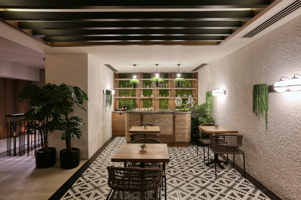 Yeşil bitkilerle dekore edilmiş modern bir kafe oturma alanı