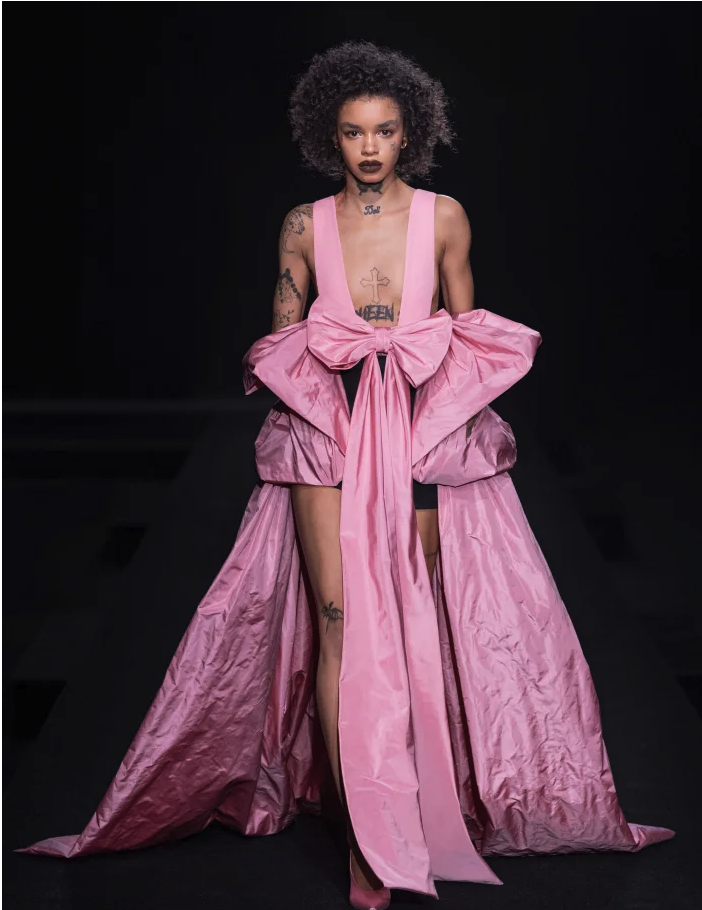 Podyumda pembe, gösterişli elbiseli ve kıvırcık saçlı model