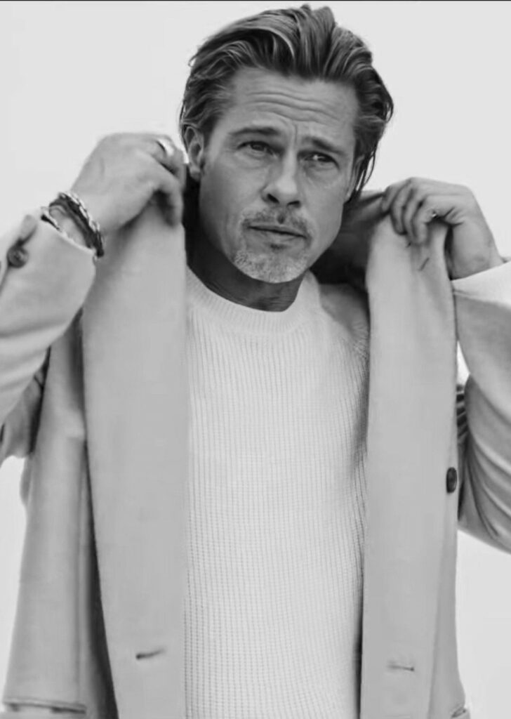 Brad Pitt, siyah beyaz portre, elleri ceket yakasında, kameraya bakıyor