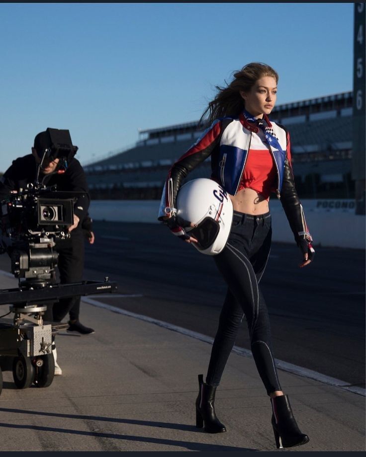 Model Gigi Hadid yarış pistinde kameramanla motosiklet kaskı taşıyor