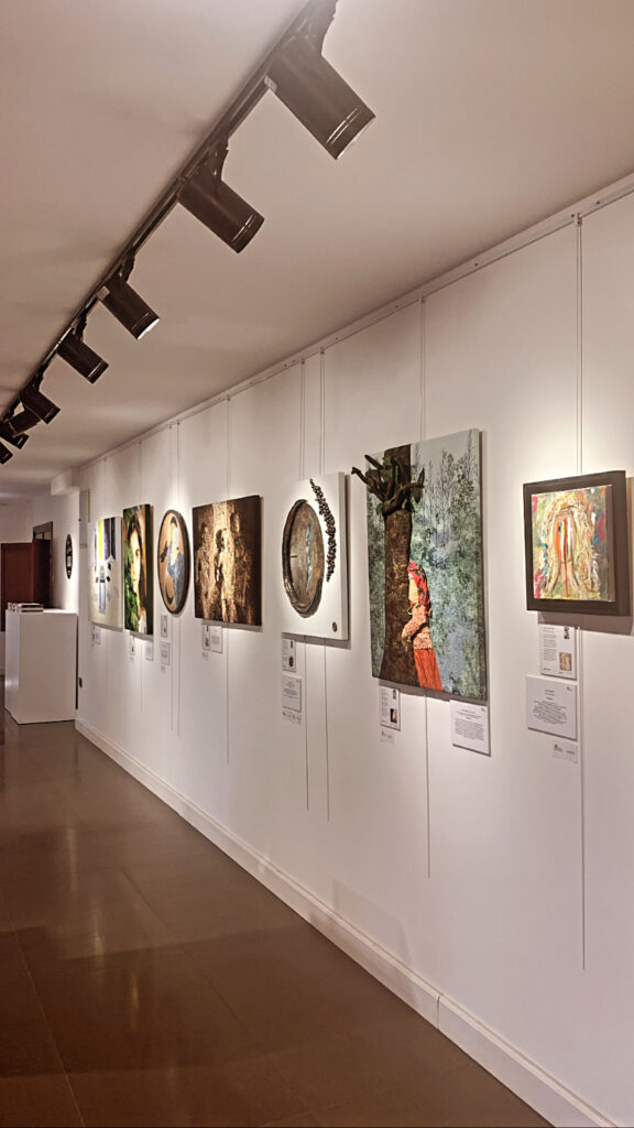 Sanat galerisinde duvarda asılı tablolar ve tavan spot ışıkları