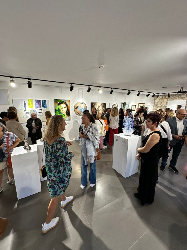 Sanat galerisinde insanlar resim ve heykellere bakıyorlar