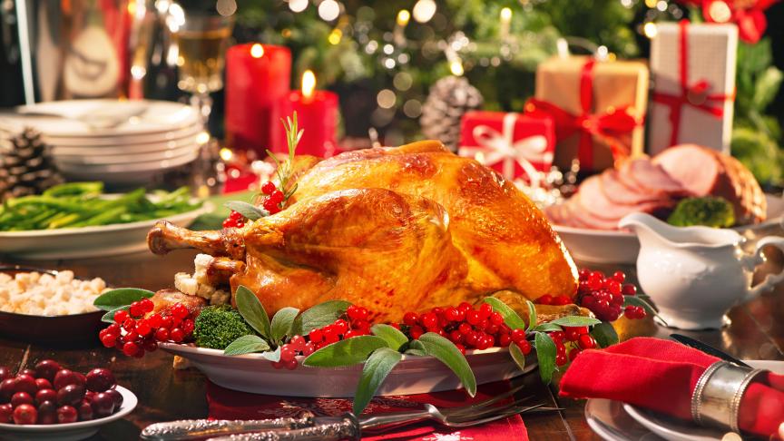 Noel yemeği sofrasında kızarmış hindi kırmızı meyveler ve yılbaşı ışıkları