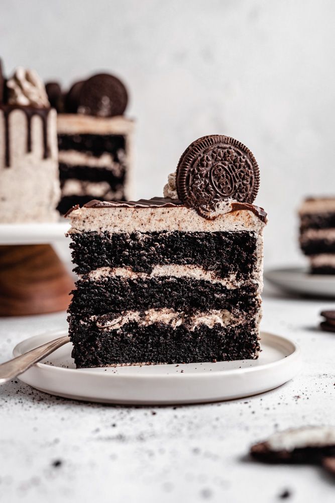Beyaz tabakta kremalı ve Oreo bisküvili üç katlı çikolatalı kek dilimi