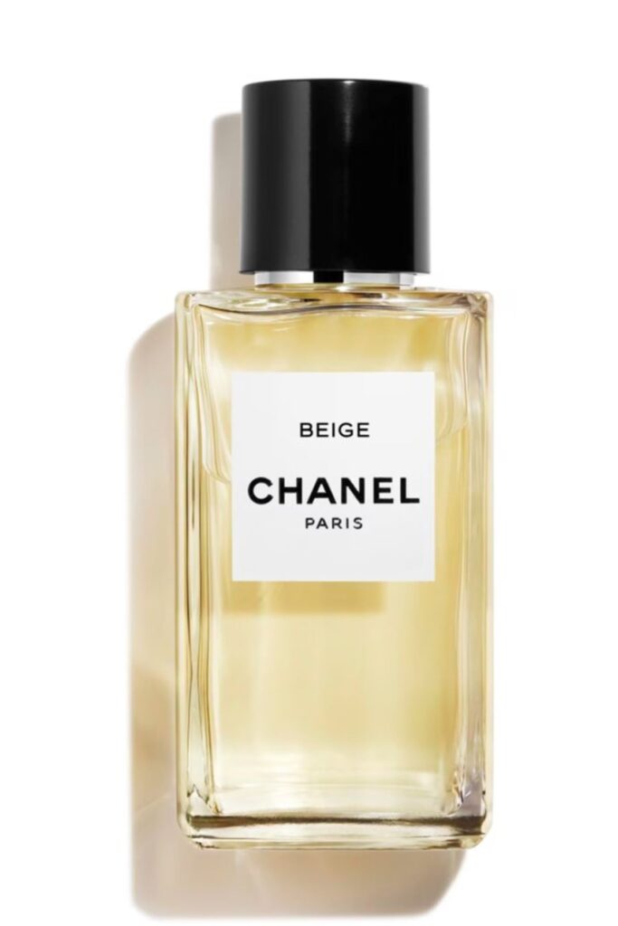 Şeffaf şişede altın sarısı Chanel BEIGE parfümü beyaz arka planda