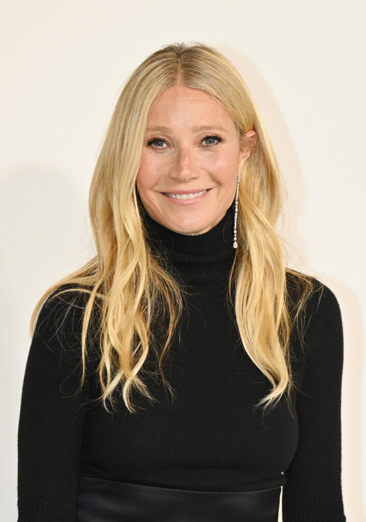 Gwyneth Paltrow siyah boğazlı kazak ve uzun küpelerle gülüyor