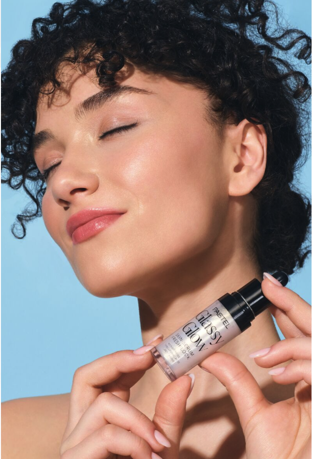 Parlak tenli gülümseyen kadın Pastel Glassy Glow serum tutuyor