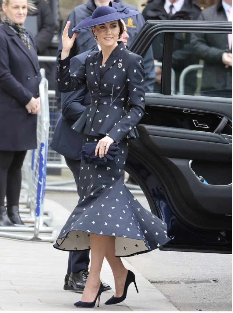 Lacivert elbise, şapka giymiş Kate Middleton arabadan inerken gülümsüyor