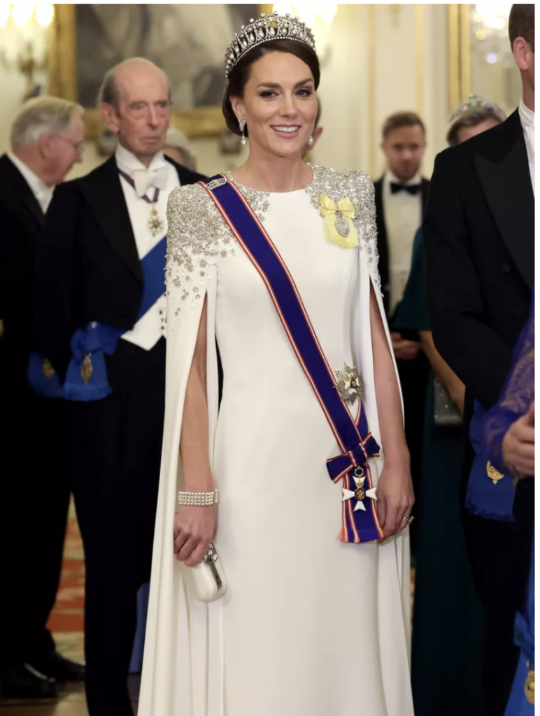 Kate Middleton beyaz elbisesi, taç ve nişanlarla kraliyet balosunda gülümsüyor