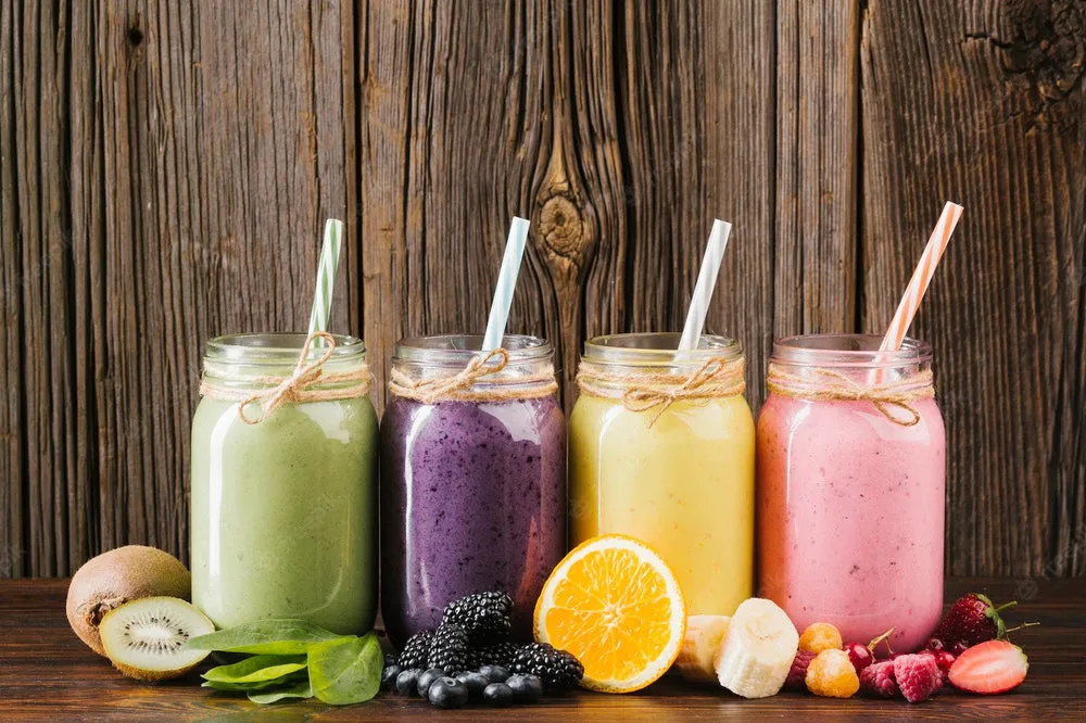 Dört renkli sağlıklı smoothie taze meyvelerle ahşap masa üzerinde