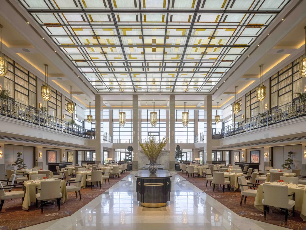 Lüks restoran salonu yüksek tavanlı vitray süslemeli şık masa düzeni