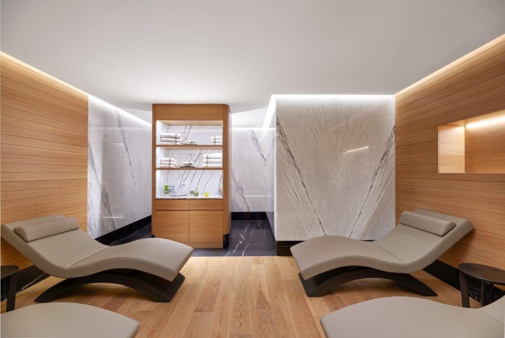Modern spa dinlenme odasında ahşap, mermer ve rahat şezlonglar