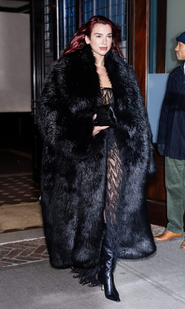 Kırmızı saçlı Dua Lipa siyah kürk palto içinde şık bir şekilde yürüyor
