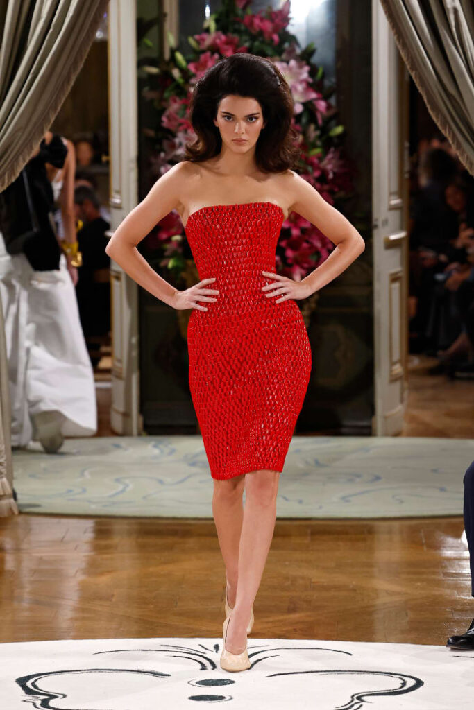 Kendall Jenner kırmızı straplez elbise ile podyumda yürüyor