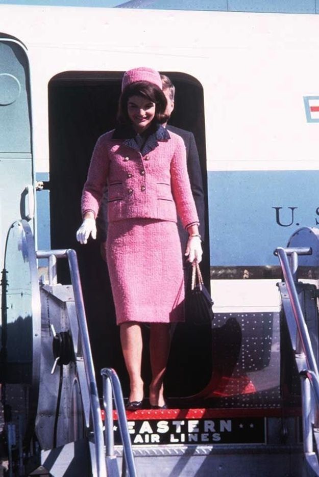 Jacqueline Kennedy pembe takımı ve şapkasıyla uçaktan inerken gülümsüyor