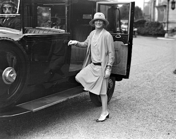 Coco Chanel şık kıyafetlerle bir otomobilden iniyor