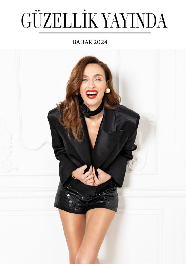Gülümseyen kahverengi saçlı kadın siyah payetli şort ve blazer giymiş