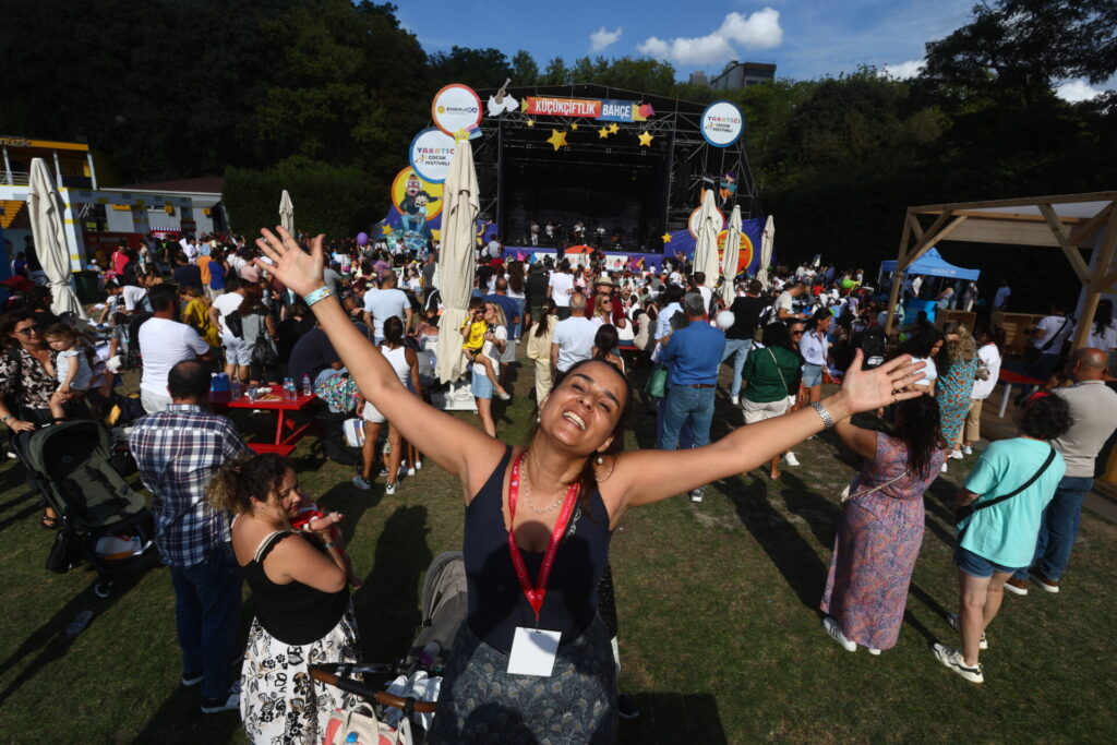 Kollarını açmış neşeli kadın kalabalık açık hava festivalinde sahne önünde