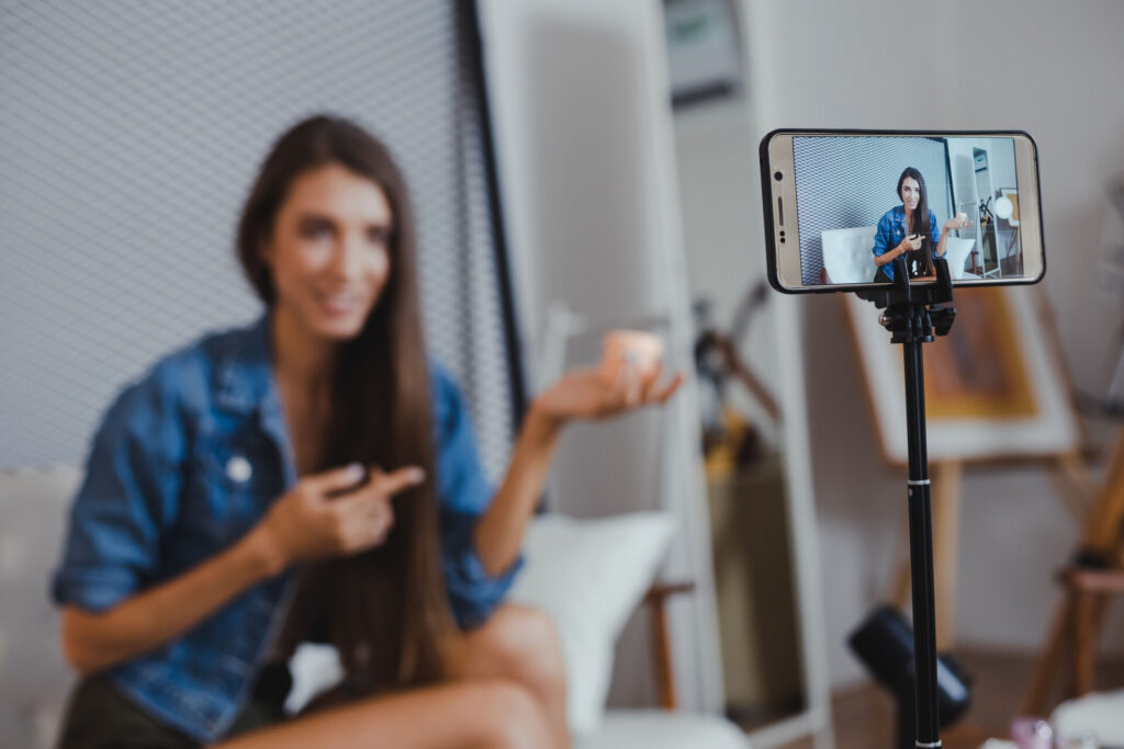 Kadın, tripoda takılı telefonla video çekerken kendini kaydediyor