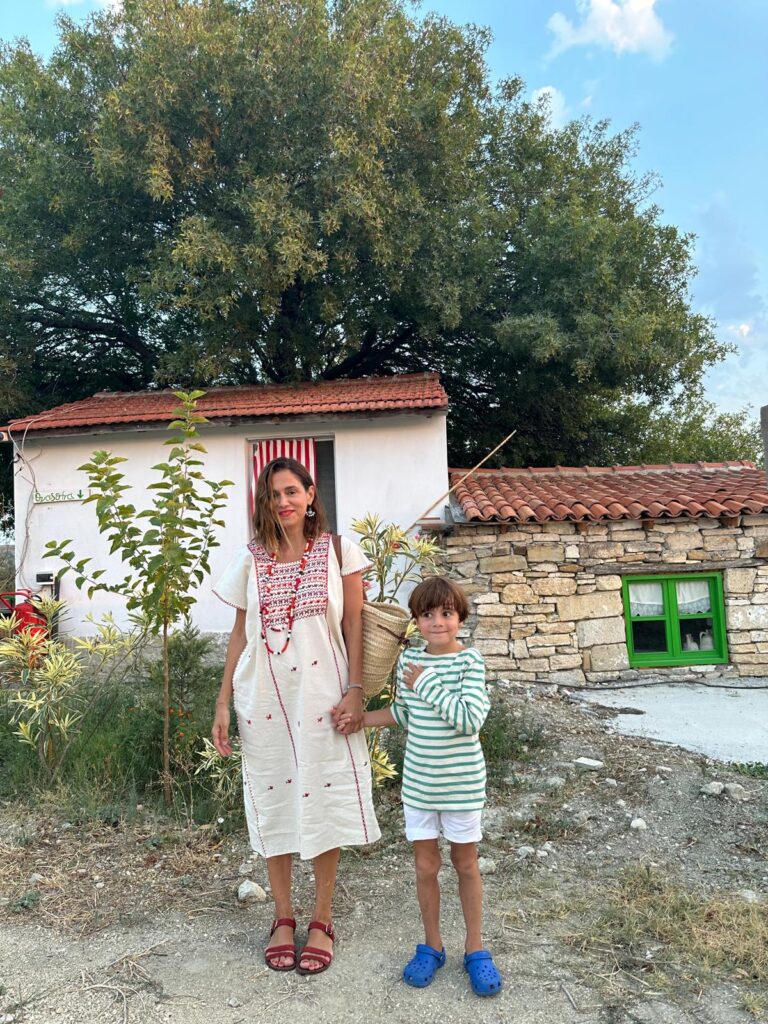 Anne ve oğlu kırsal bir ev önünde el ele duruyorlar
