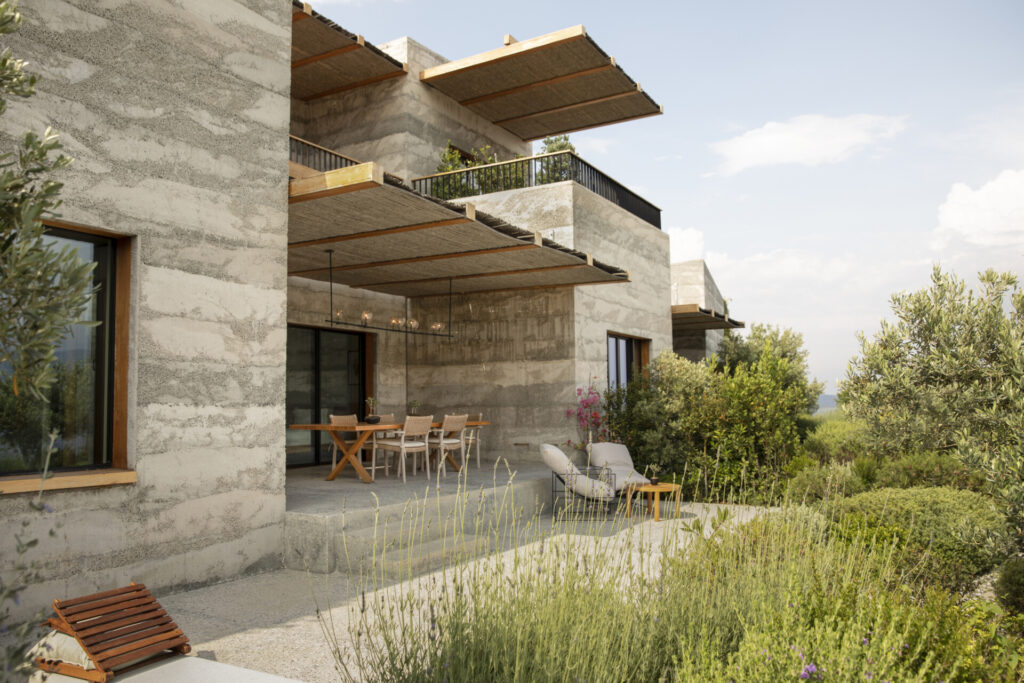 Beton duvarlı modern ev ahşap gölgelikler ve Akdeniz bitki örtüsüyle teras