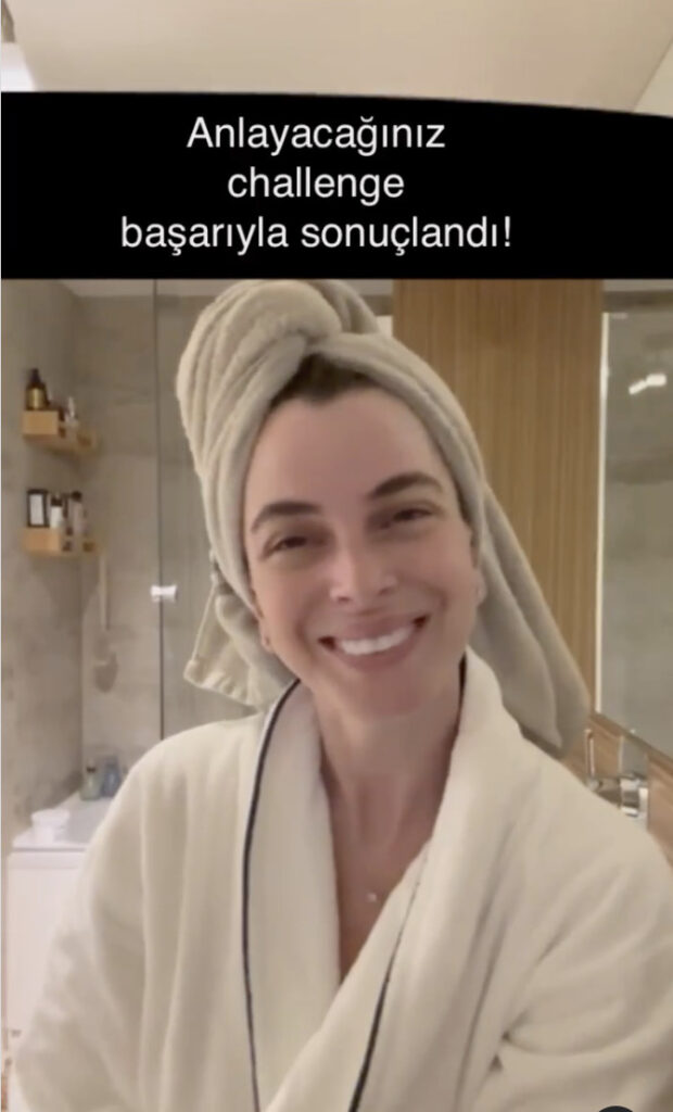 Banyoda havlu sarılı ve bornozlu gülümseyen kadın