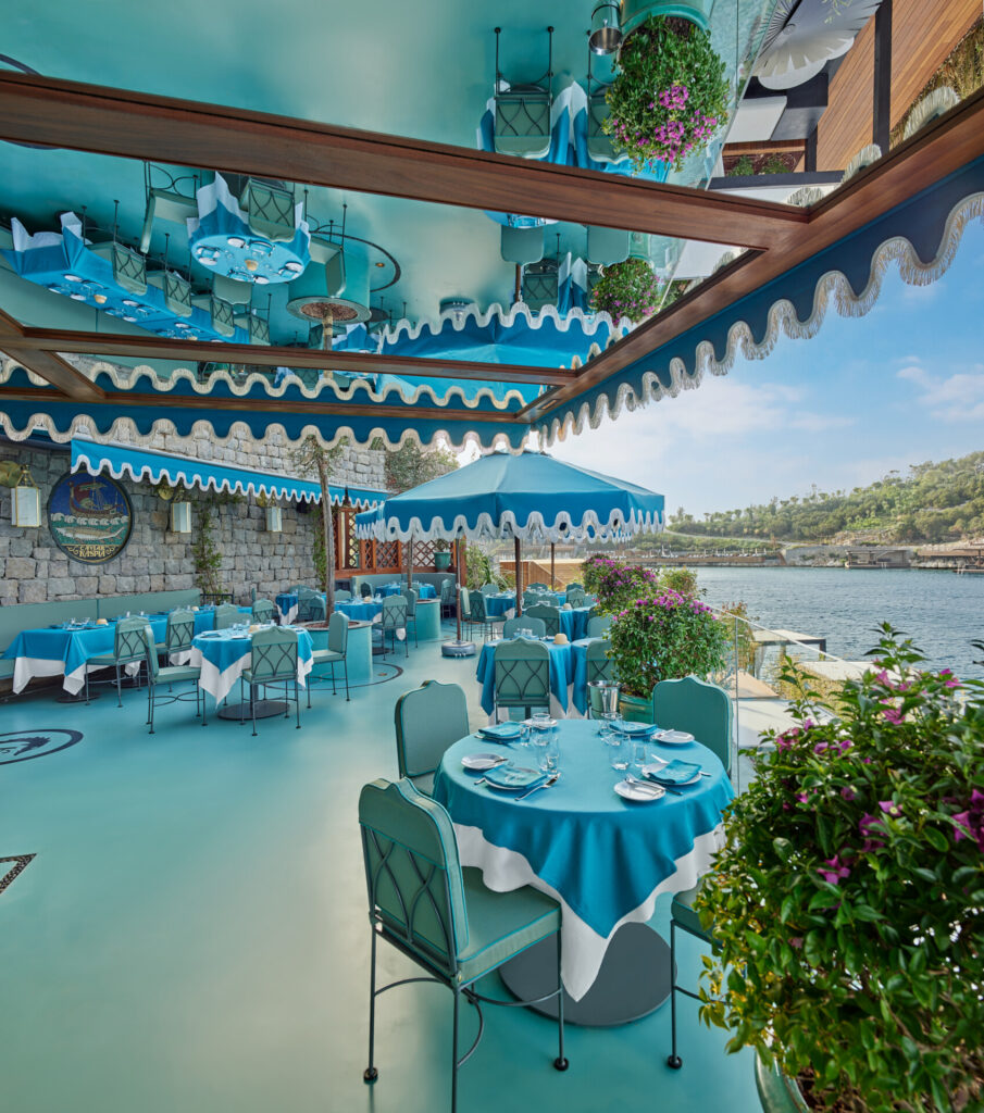 Aynalı tavanlı, mavi dekorlu deniz kenarı açık hava restoranı manzarası