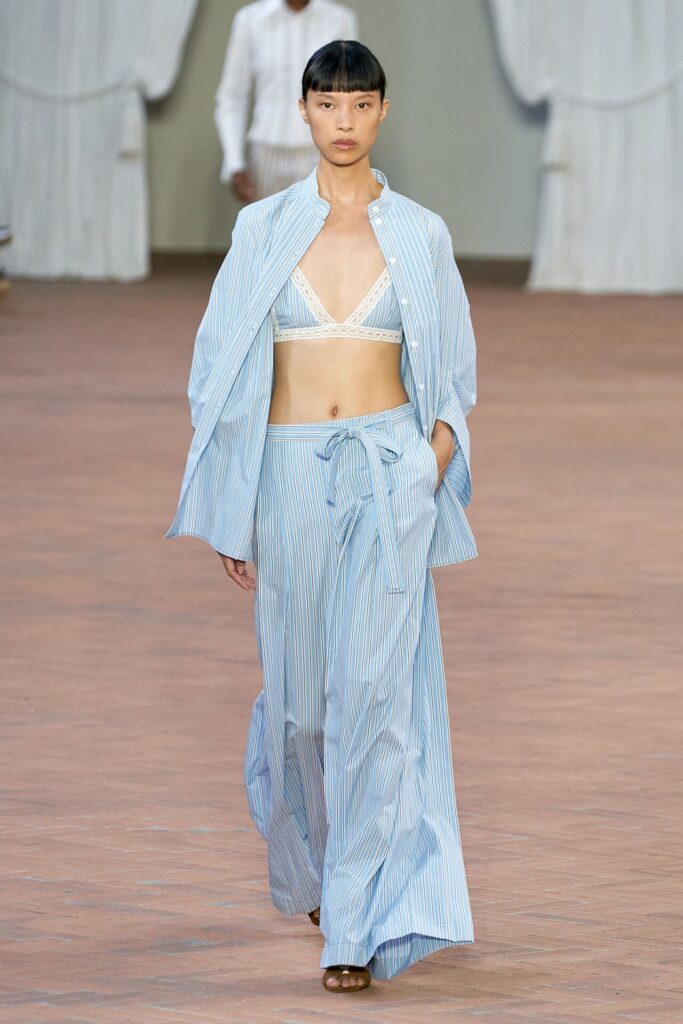 Podyumda mavi çizgili pijama takım ve beyaz bralet giyen model