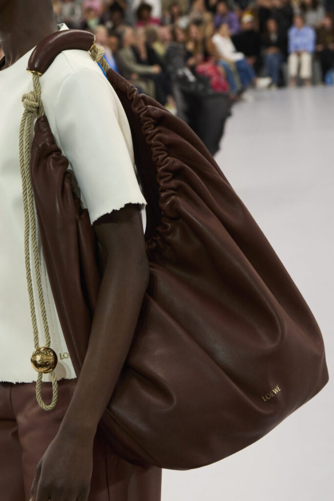 Model defilede kahverengi Loewe deri çantayı halat askısıyla taşıyor
