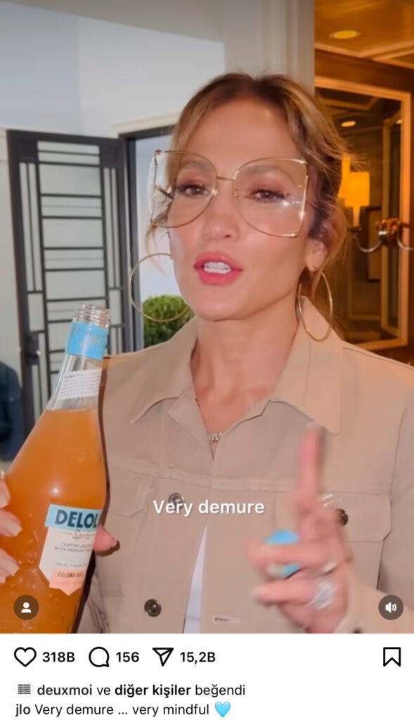 Jennifer Lopez büyük gözlükler ve bej ceketle Delola içeceğini tanıtıyor