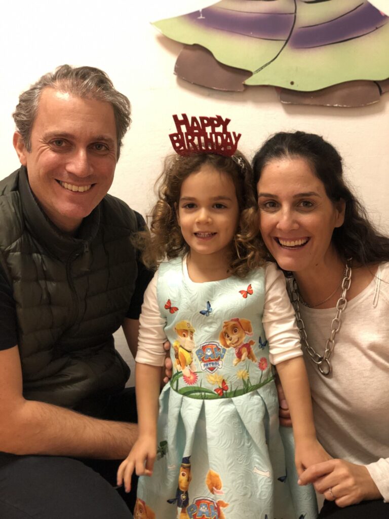 Paw Patrol elbiseli doğum günü kızı anne ve babasıyla gülümsüyor