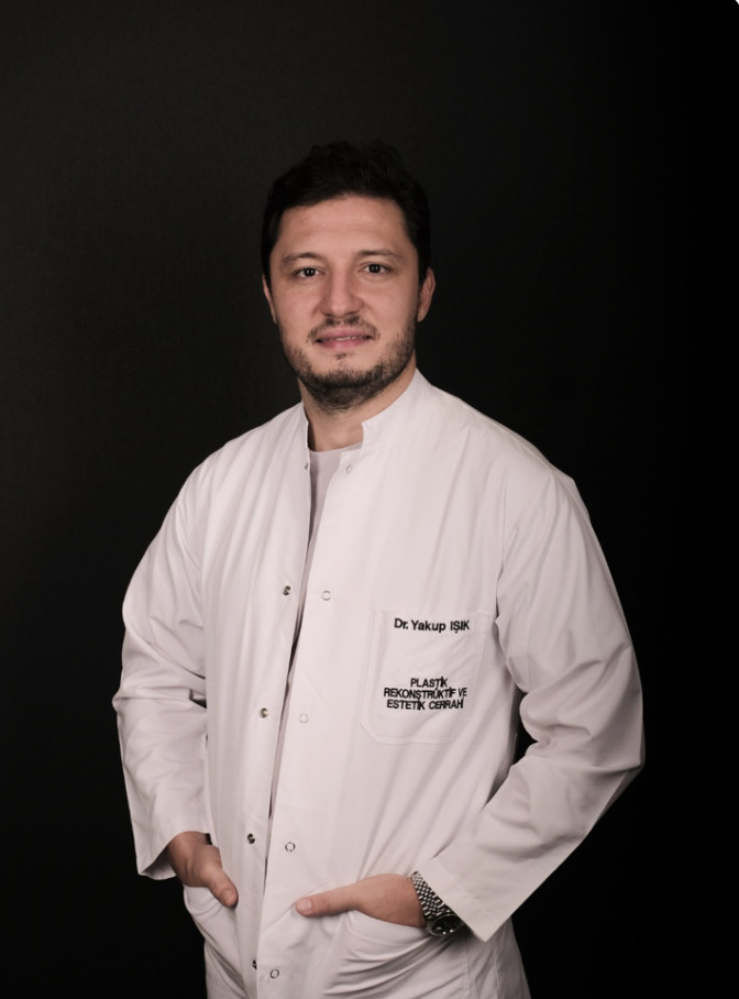 Plastik ve estetik cerrah Dr Yakup Işık beyaz önlüklü gülümsüyor