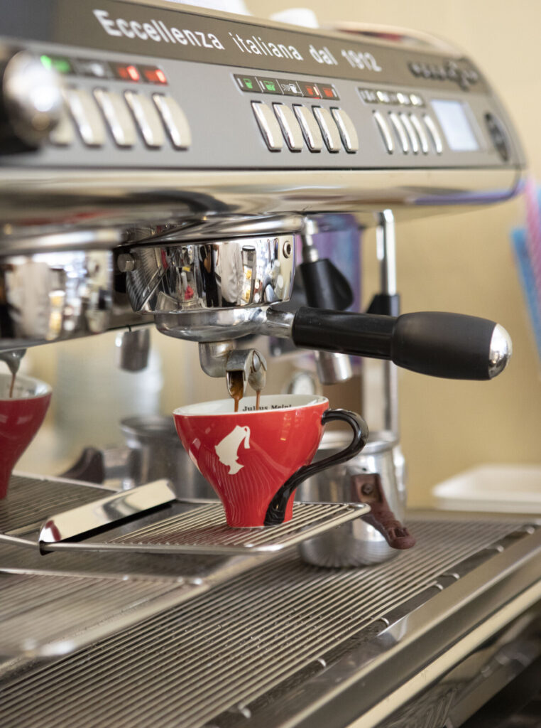 Kırmızı Julius Meinl fincanına espresso makinesinden taze kahve yapılıyor