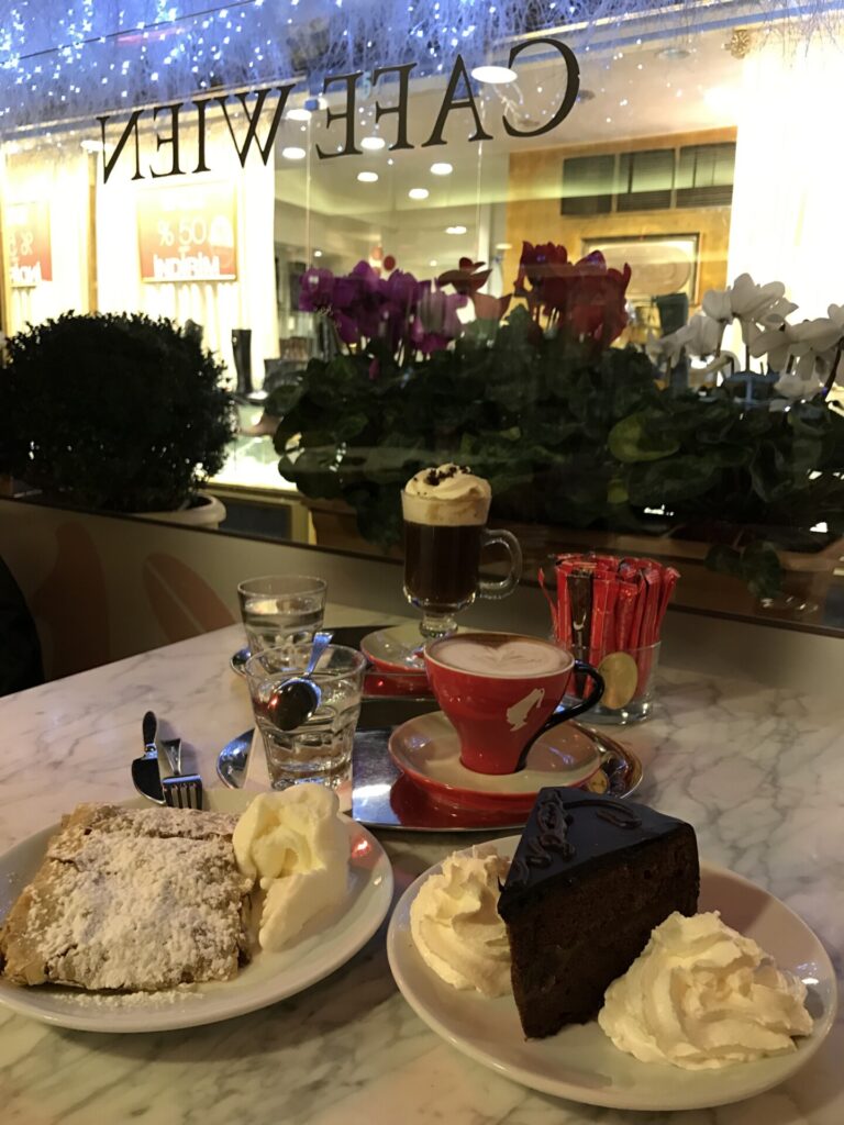 Cafe Wien'de tatlılar ve kahvelerle dolu mermer bir masa