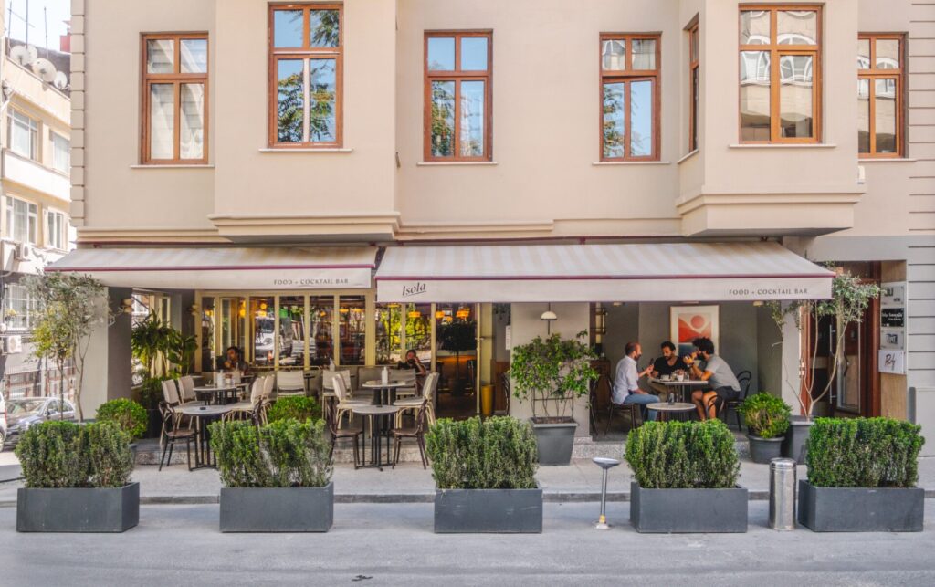 Isola adlı kafe restoranın dış cephesi, masalar ve insanlar