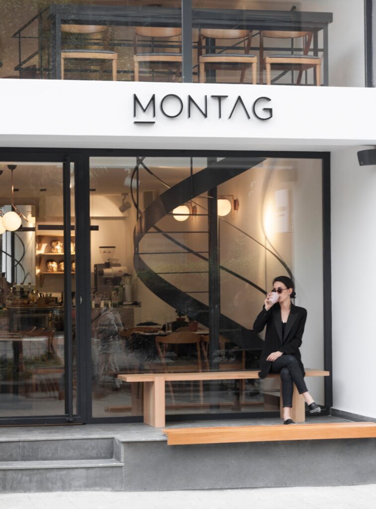Montag kafenin önünde oturan ve içecek içen bir kadın