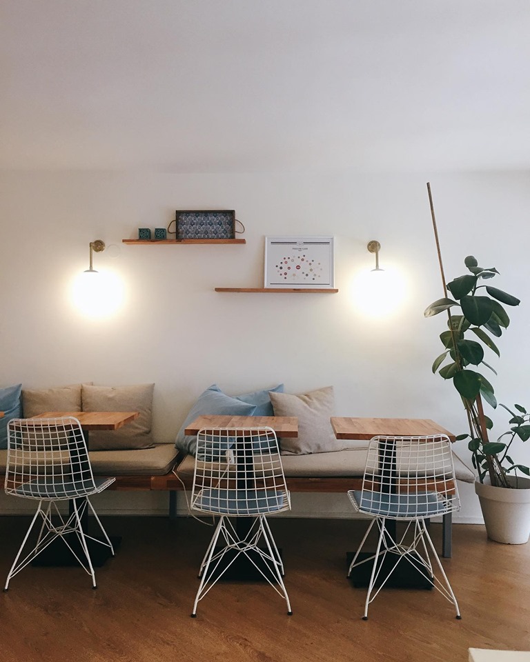 Sıra sıra oturma düzenine sahip, sade ve modern bir kafe içi