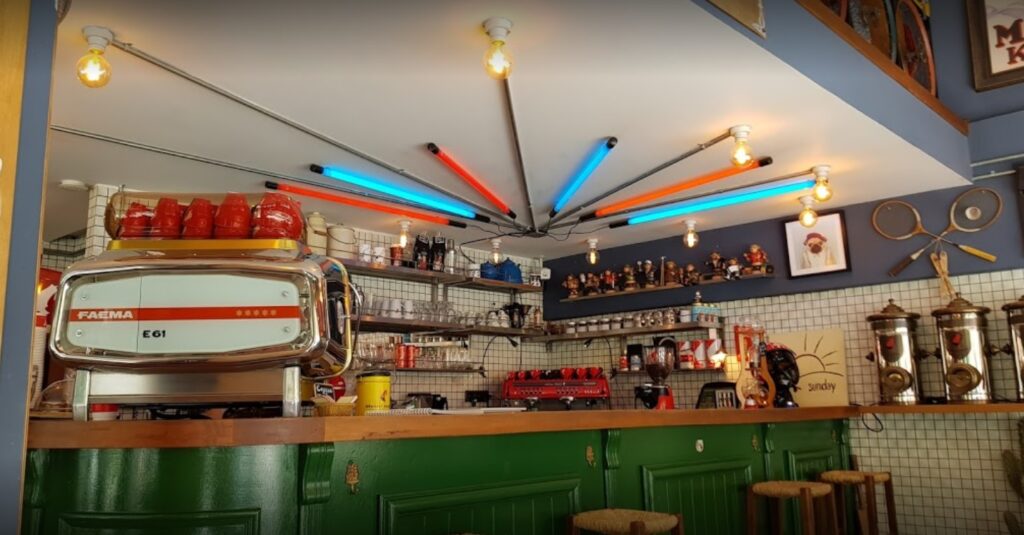 Renkli neon ışıklar retro kahve makinesi ve yeşil tezgahlı bir kafe