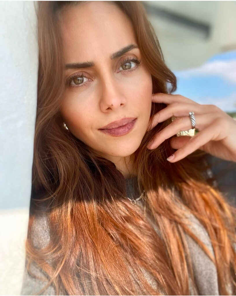 Gülümseyen kızıl saçlı ela gözlü bir kadın portresi