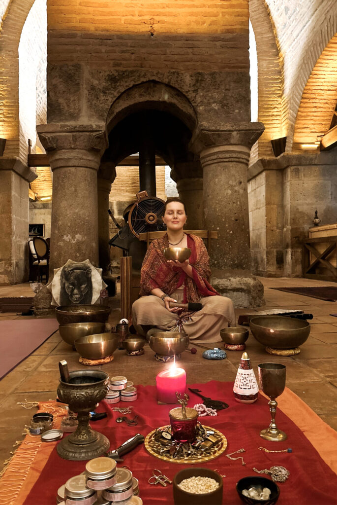 Tarihi kemerli odada şarkı kasesiyle meditasyon yapan huzurlu kadın