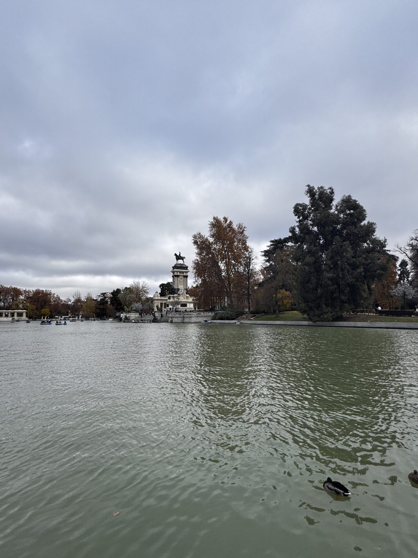 Retiro Parkı'nda bulutlu günde göl ve Kral IV Alfonso anıtı