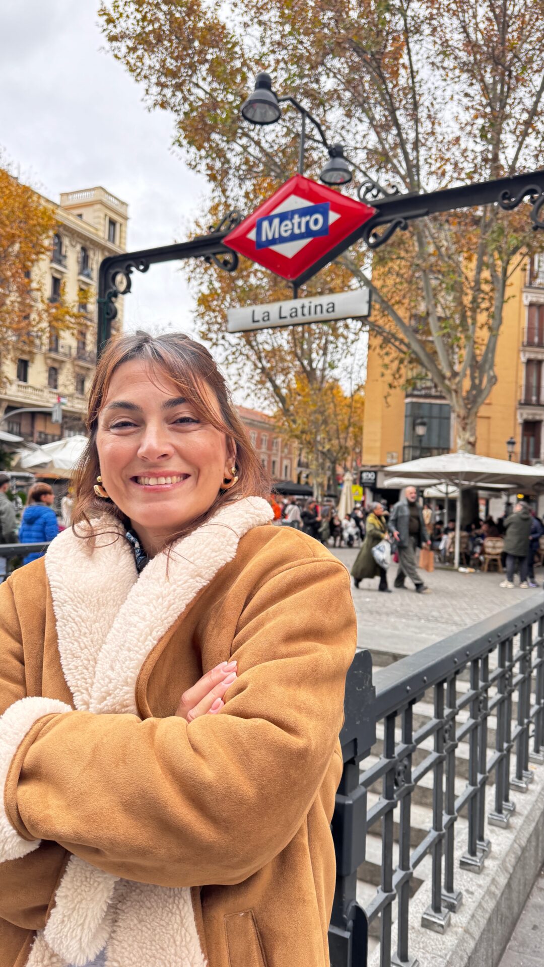 Kahverengi paltolu gülen kadın Madrid La Latina metrosu önünde