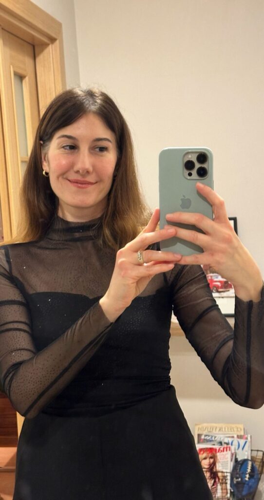 Aynada selfie çeken siyah şeffaf bluzlu genç bir kadın