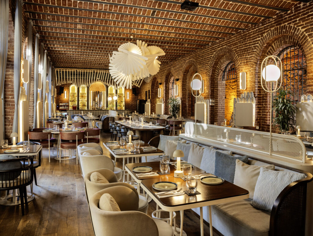Tuğla duvarlı, kemerli ve şık aydınlatmalı modern restoran iç mekanı