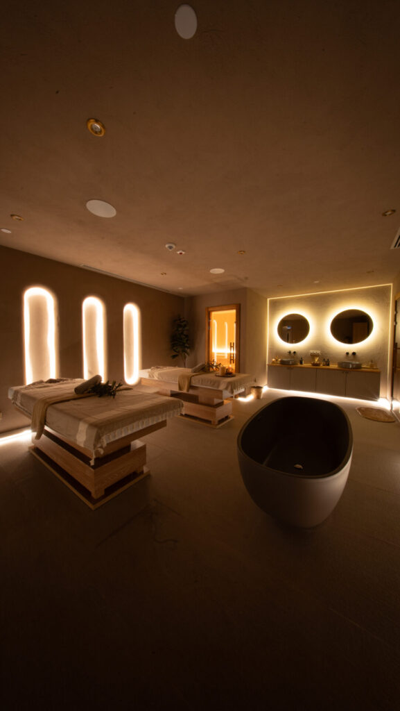 Sakinleştirici ortam ışıklı, iki masaj yatağı ve küvetli modern spa odası