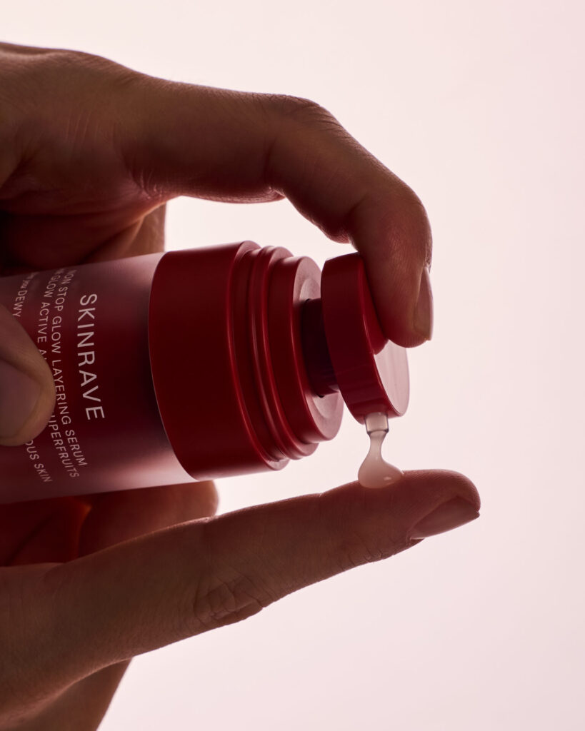 Kırmızı Skinrave şişeden parmağa damlayan serum yakın plan el